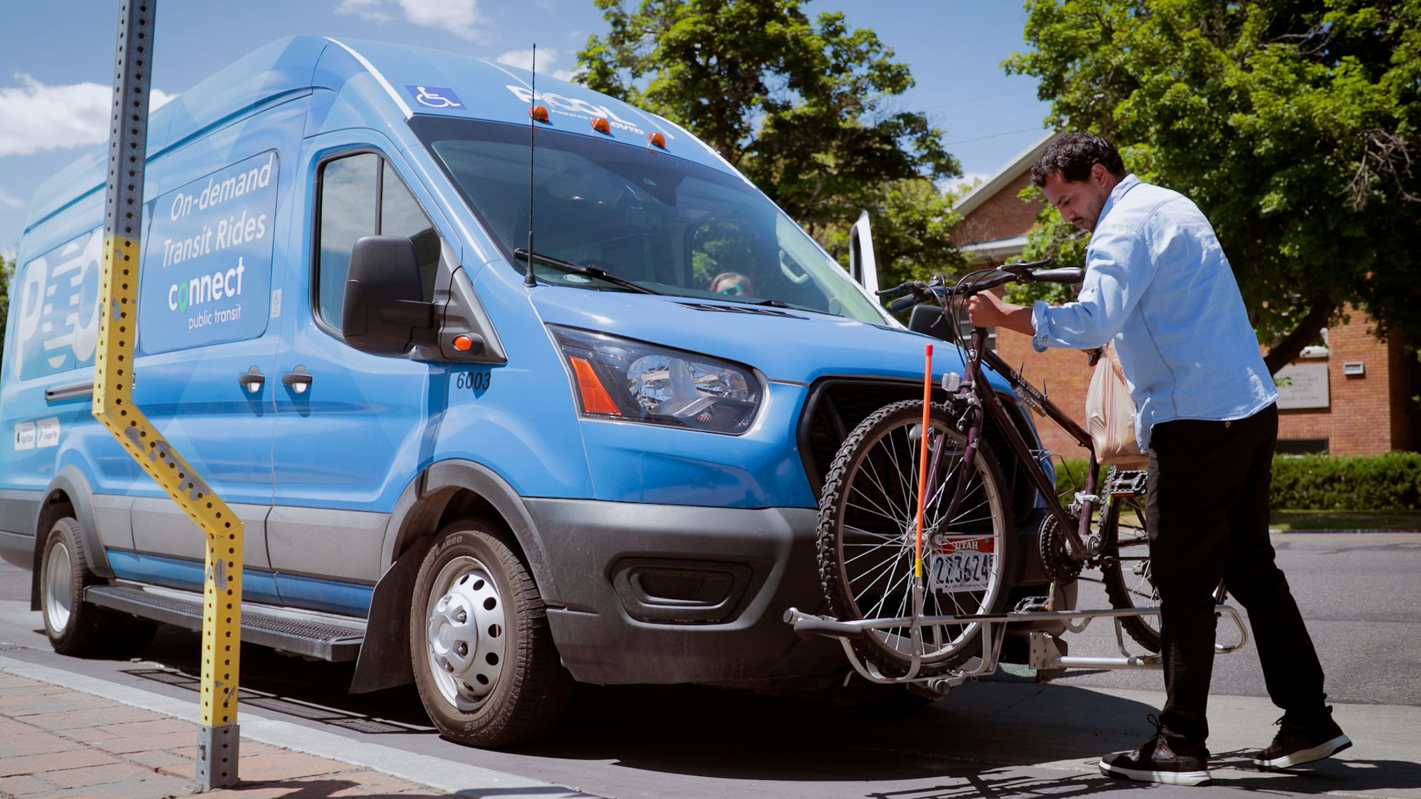 man loading a bike on a connect transit bus